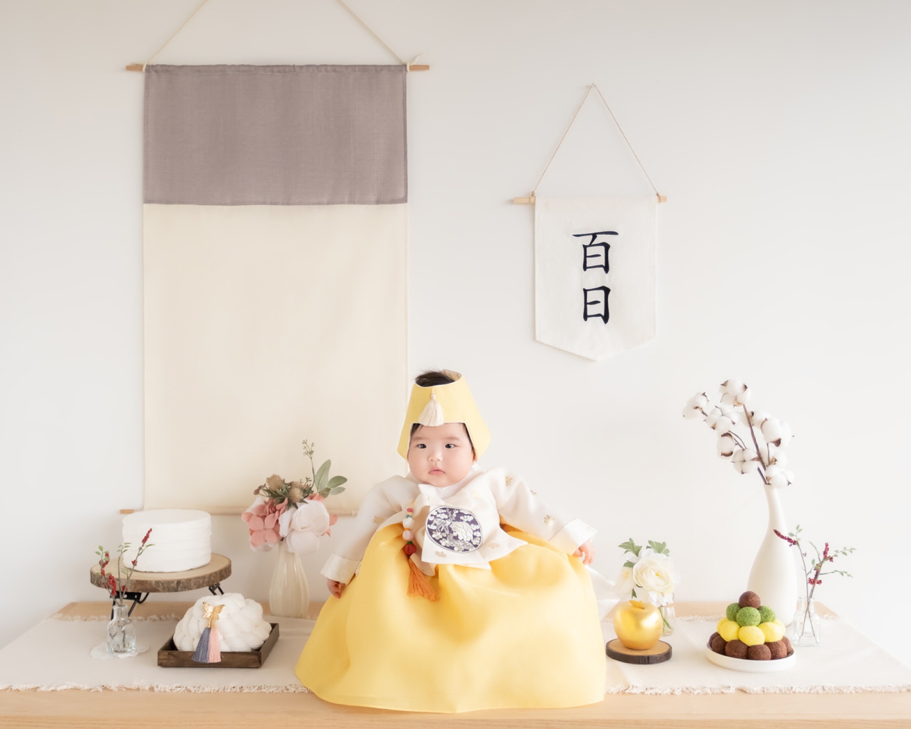 Baby in yellow hanbok at a 100-day portrait session