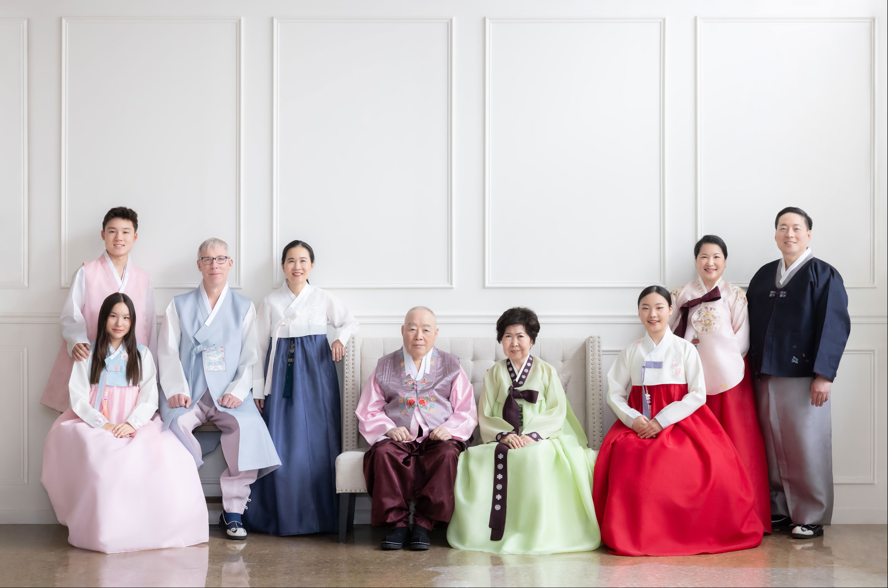 Multigenerational family photographed together in hanbok.