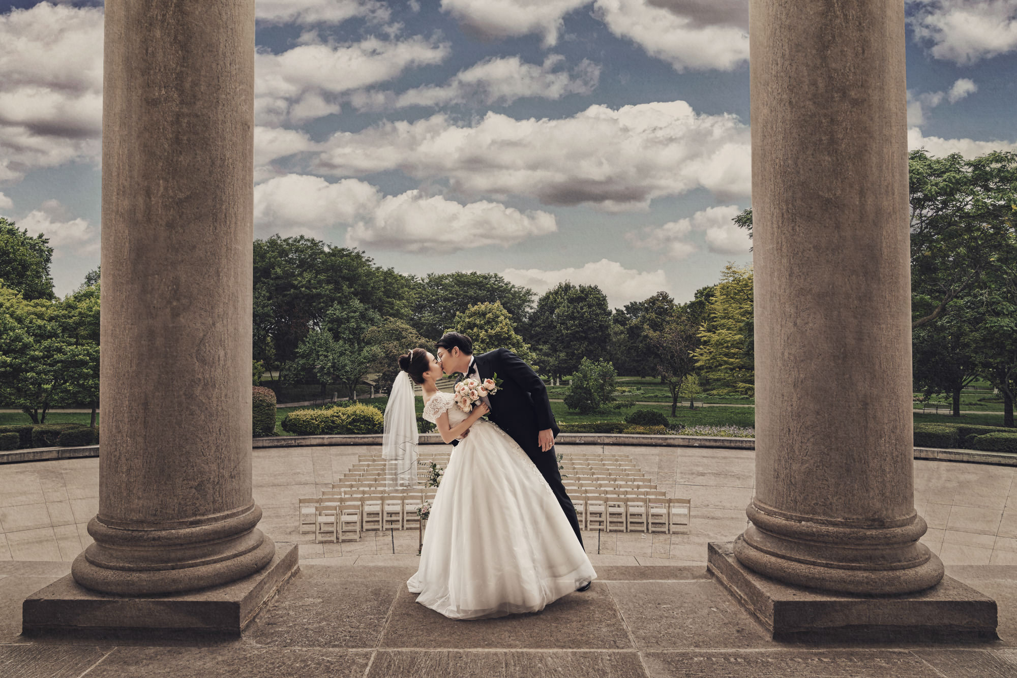 Wedding couple between columns at the Chicago History Museum, with ceremony seating behind them