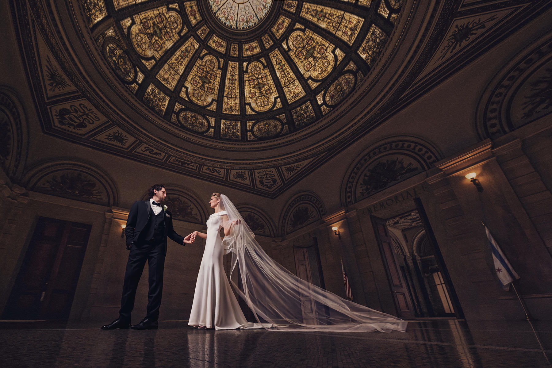 Leslie and Rob holding hands beneath the dome of the Chicago Cultural Center