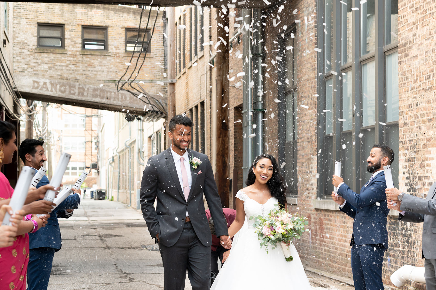 Rebecca and Samuel leaving their wedding ceremony with their guests.